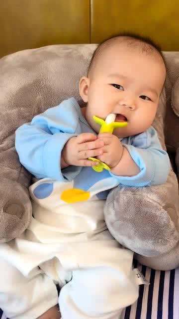 这个小宝宝真可爱,懒洋洋地倚在大象玩具上,看什么呢